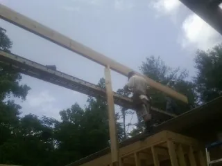 Carpenter setting a ridge beam over a new addition frame — Ice Dam Removal by Roofing Brothers in Pigeon Forge