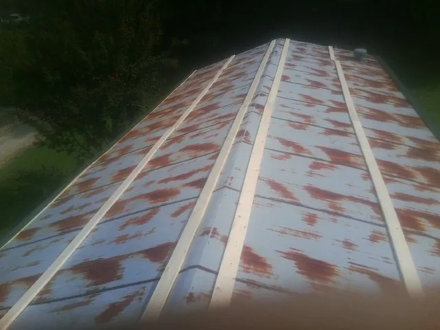 Rusted metal roof panels with new wood purlins before replacement — Storm Damage Roof Repair in Pigeon Forge by Roofing Brothers