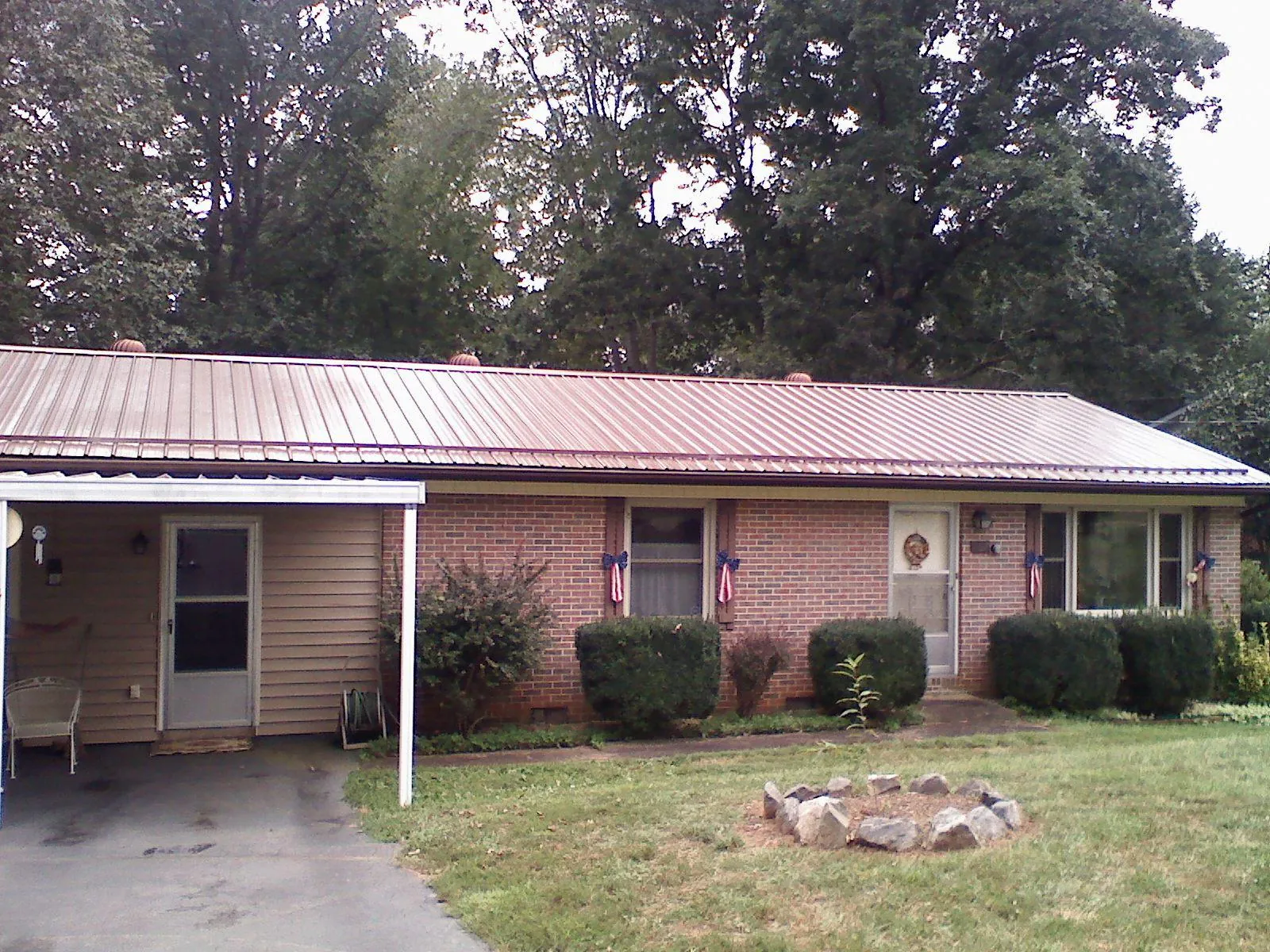 Bronze metal roof and carport on a brick ranch home — Roof Repair work by our crew in Pigeon Forge